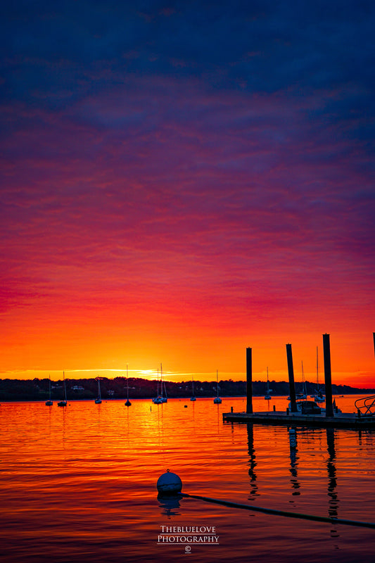 Harbor Sunset: Fiery Orange Sky Over Serene Boats